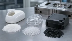 Three groups of engineering resin pellets beside molded plastic housings and a steel mold insert on a clean inspection bench.