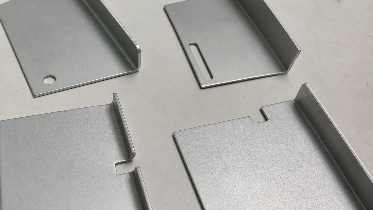 Sheet metal bend samples with holes, slots, notches, and reliefs near formed edges.
