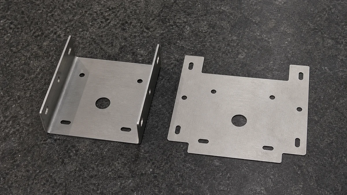 Finished bent bracket displayed beside the flat sheet blank used to form it.